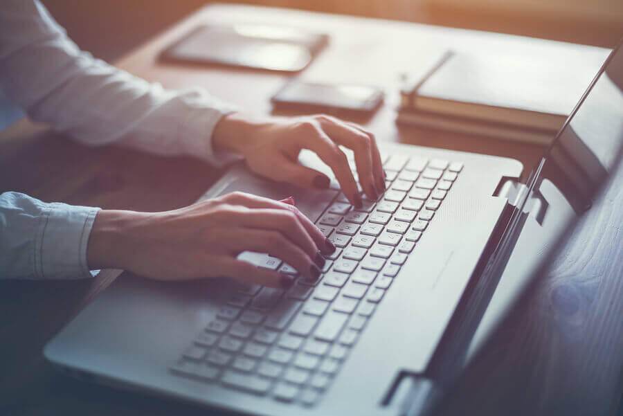 A woman typing on a laptop