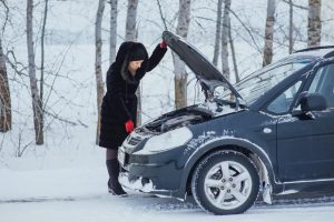 A woman looking under the bonnet of her car