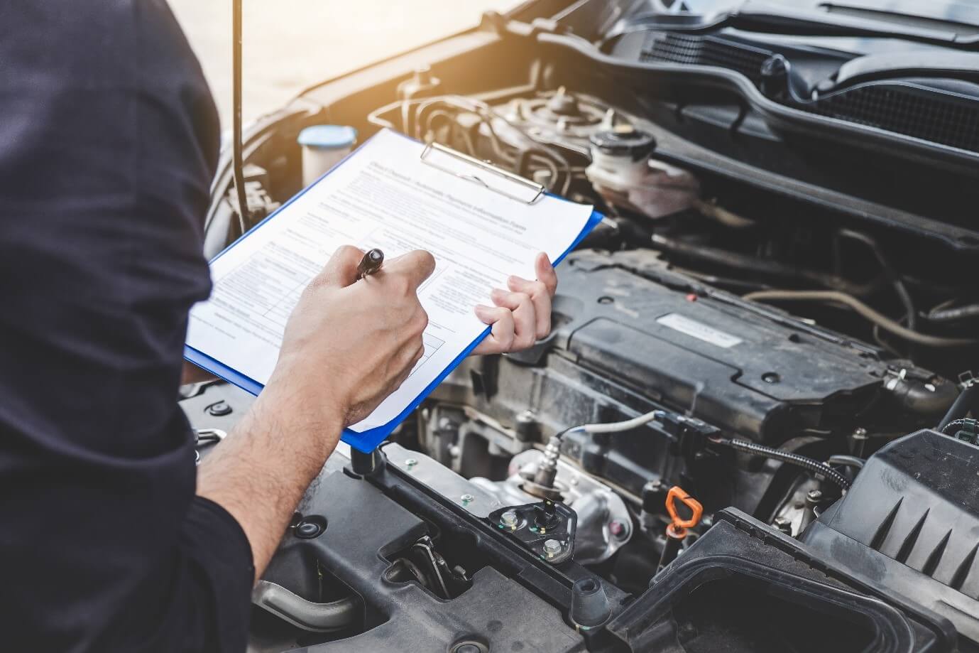 A Mechanic looking at a car engine